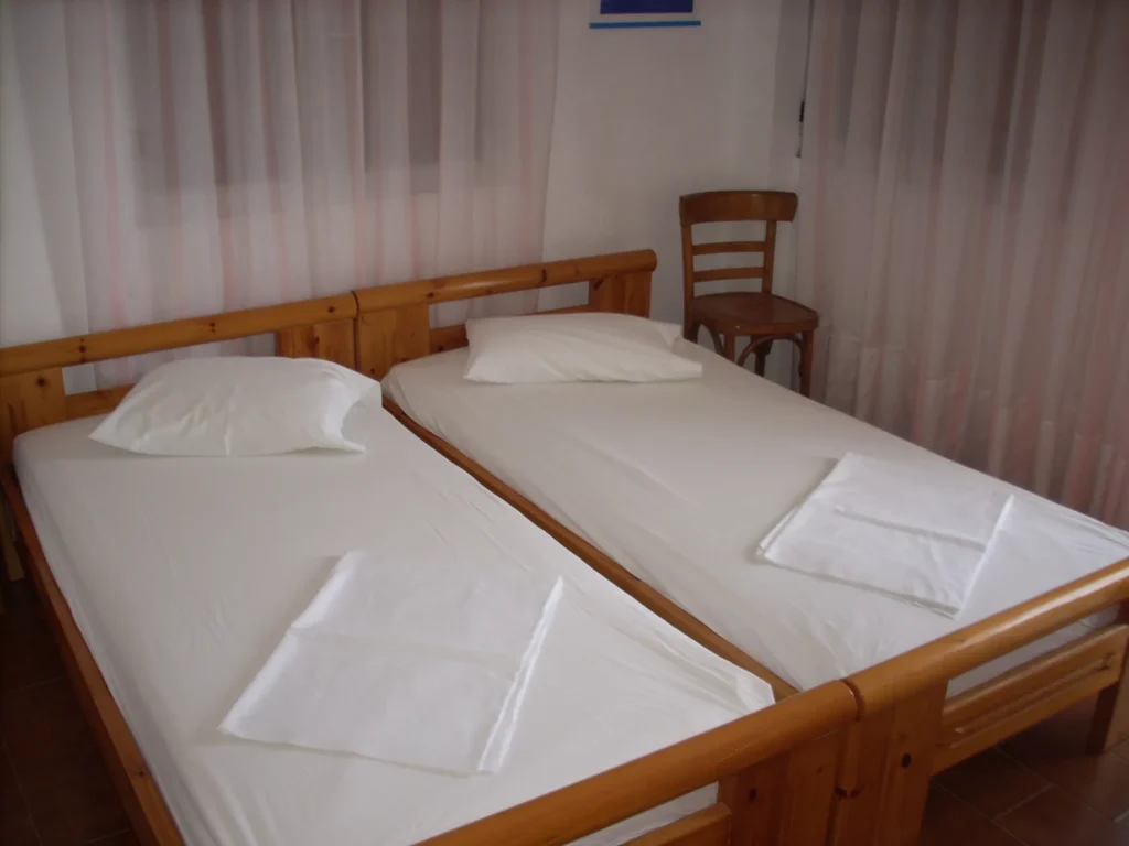 Bedroom with two single wooden beds at Olympia House