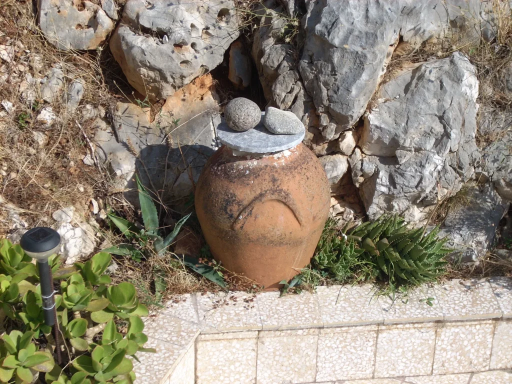 Clay pot among the rocks in the garden of Olympia House