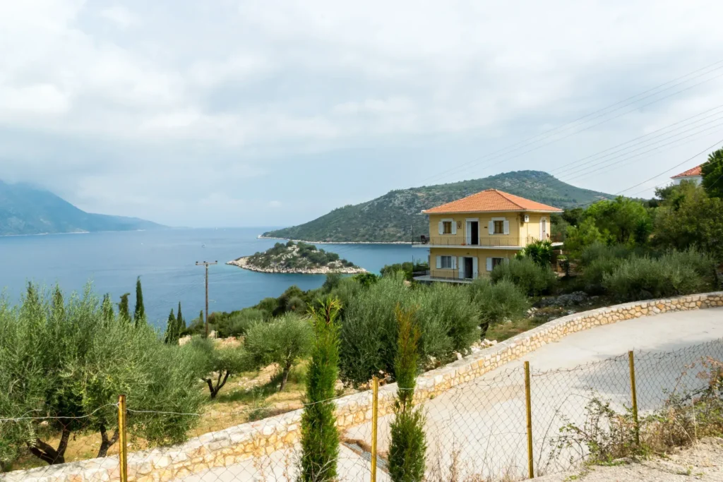 Olympia House among olive trees with the bay behind